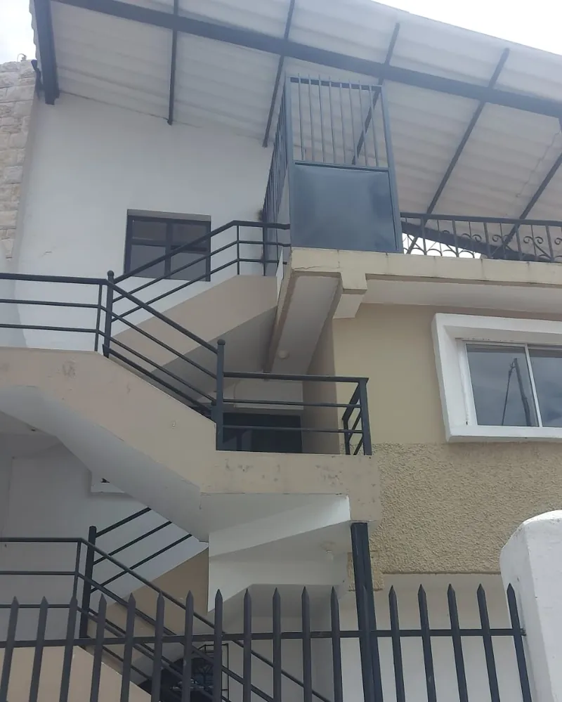 Vivienda en Playas con escalera exterior de hormigón y barandas metálicas negras.